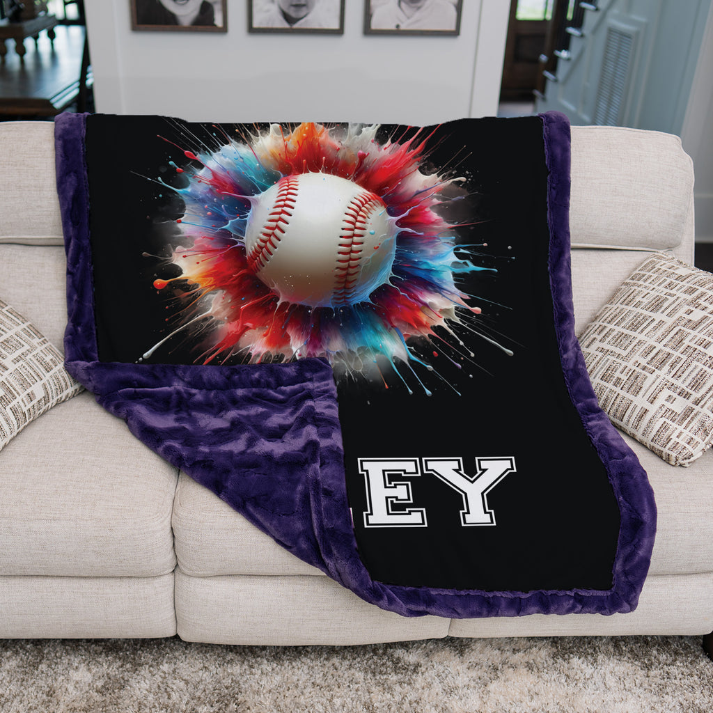 Personalized baseball minky blanket with purple minky back, folded over a cream couch
