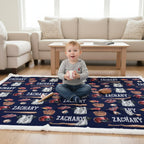 Child sitting on a personalized rug with sports-themed design and 'Zachary' printed multiple times, in a living room setting.