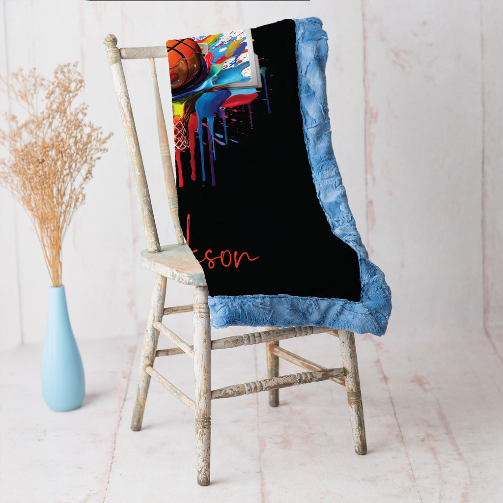 Personalized basketball Luxe Cuddle blanket draped over rustic wooden chair, blue Luxe Cuddle border visible