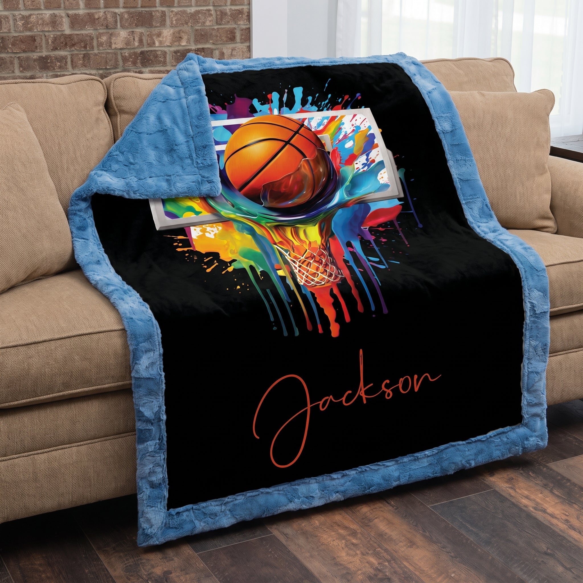 Basketball Luxe Cuddle blanket draped over sofa showing blue back panel and black print side