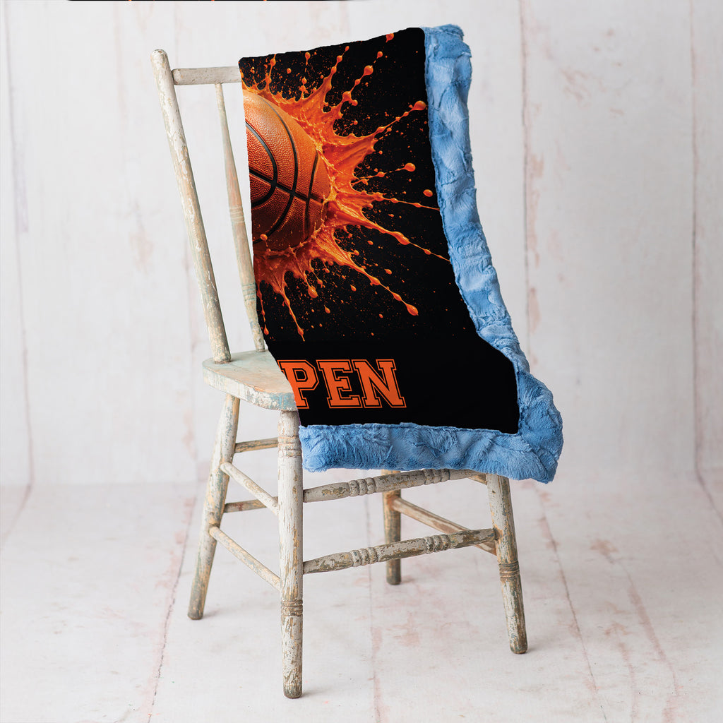 Close-up of personalized basketball minky blanket draped over vintage chair with blue trim