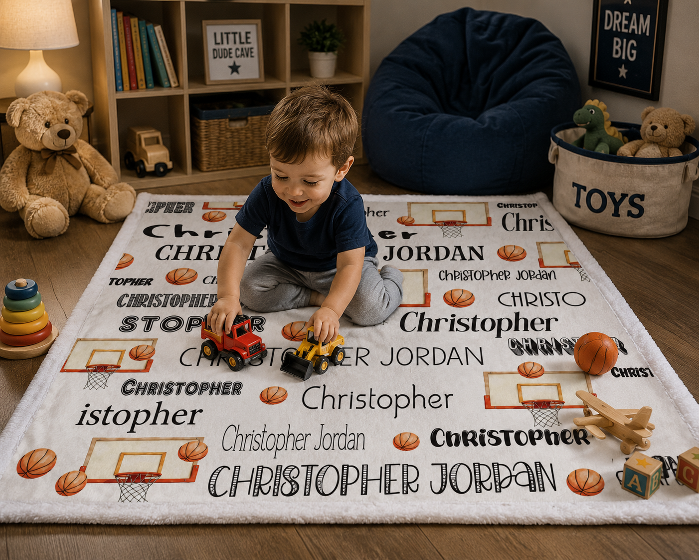 Toddler playing with toy trucks on personalized basketball name blanket with white trim