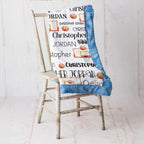 Personalized basketball name blanket with blue faux fur trim draped over rustic chair