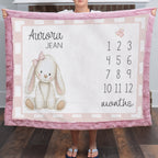 Woman holding personalized bunny milestone blanket with custom name, pink faux fur trim