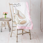Personalized bunny minky baby blanket with pink minky back, draped over rustic vintage chair