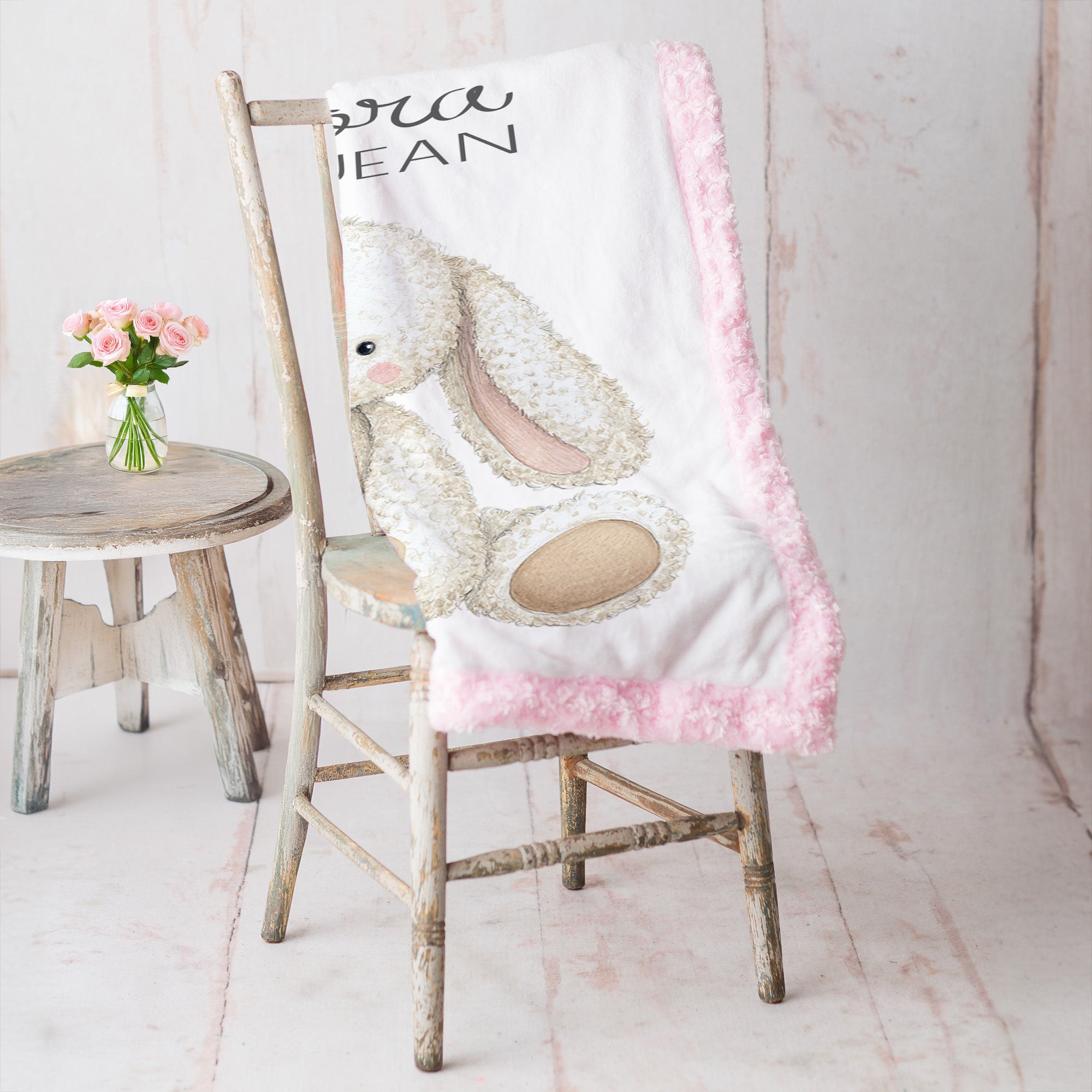 Personalized bunny minky baby blanket with pink minky back, draped over rustic vintage chair