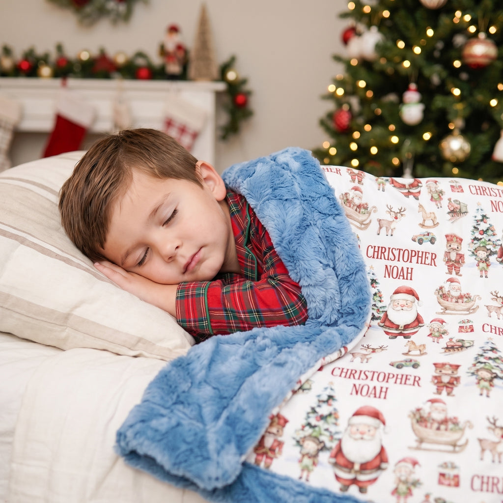 Personalized Christmas minky blanket with Santa print draped over sleeping boy by tree