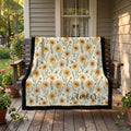 Black trim minky blanket with daisy floral print and personalized name, draped over porch swing