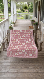 Personalized daisy minky blanket with pink trim draped over porch swing