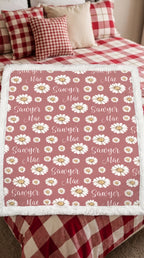 Personalized daisy minky blanket with white sherpa back draped over plaid bed