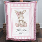 Personalized minky donkey baby blanket with mauve pink fur border by fireplace