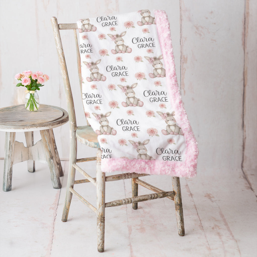 Personalized minky donkey baby blanket with pink rosette fur border on vintage chair