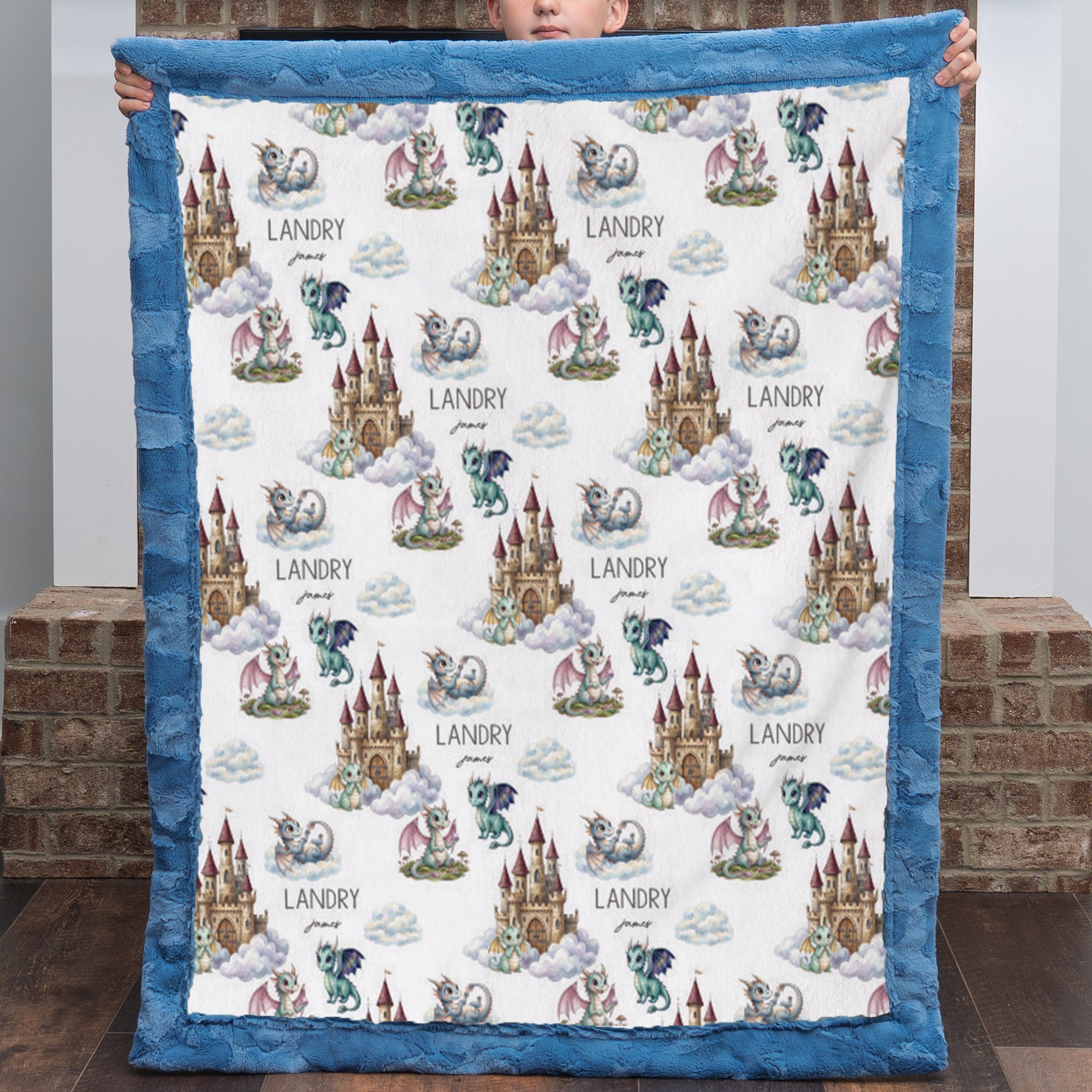 Boy holding personalized dragon castle blanket with blue trim
