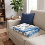 Folded personalized dragon castle blanket with blue trim on armchair