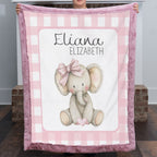 Personalized elephant minky baby blanket with mauve fur trim, held up by fireplace