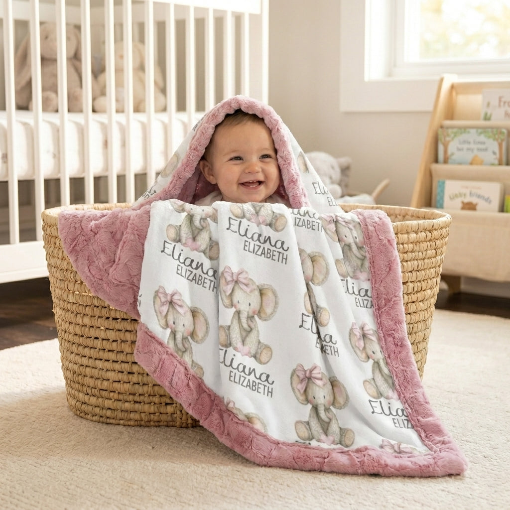 Baby wrapped in personalized elephant minky blanket with pink trim, held in wicker basket