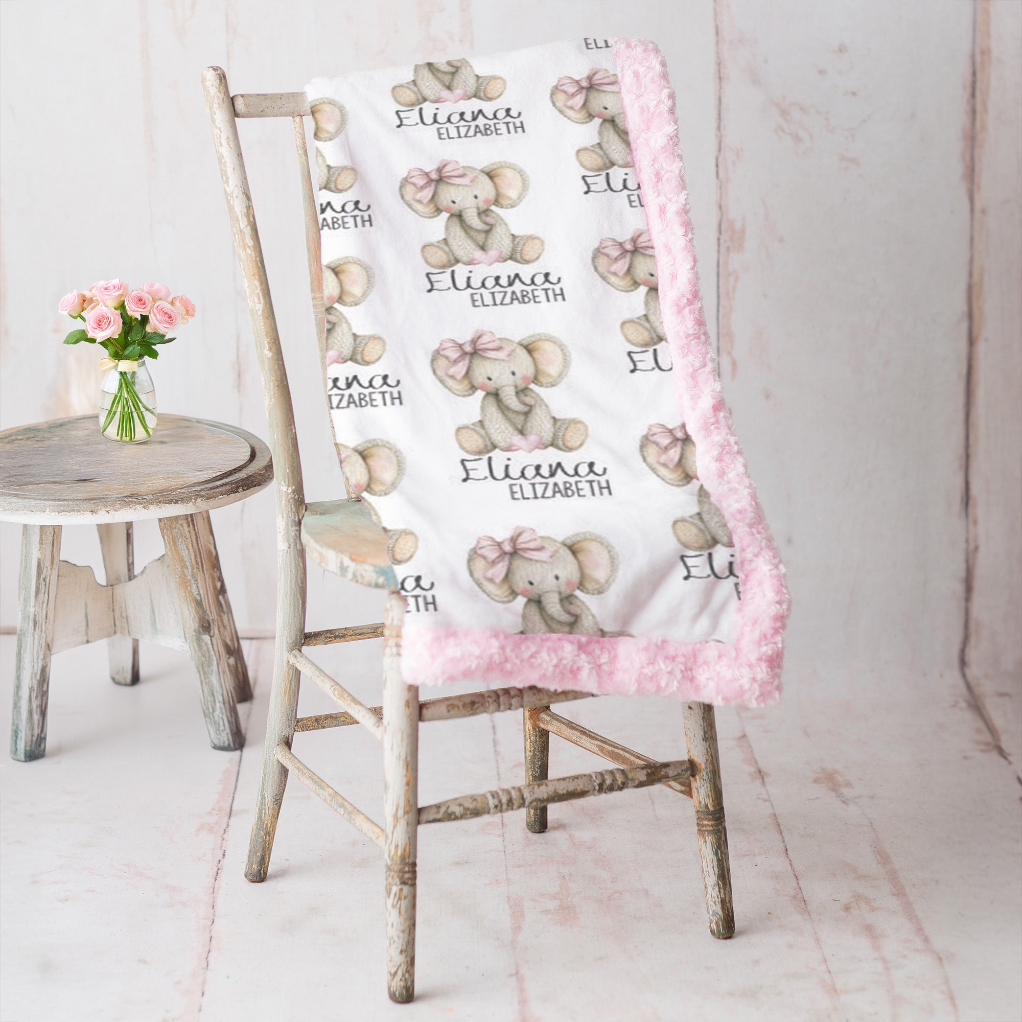 Woman holding personalized elephant baby blanket with pink minky trim by fireplace mantel