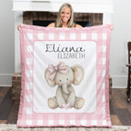 Personalized elephant minky baby blanket with pink fur trim, held up by fireplace