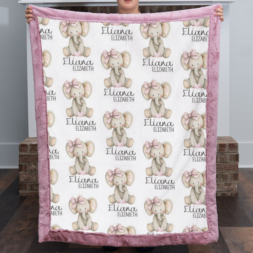 Woman holding personalized elephant baby blanket with pink minky trim indoors