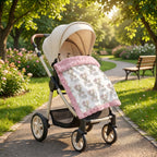 Personalized elephant baby blanket with pink minky trim draped over stroller in park