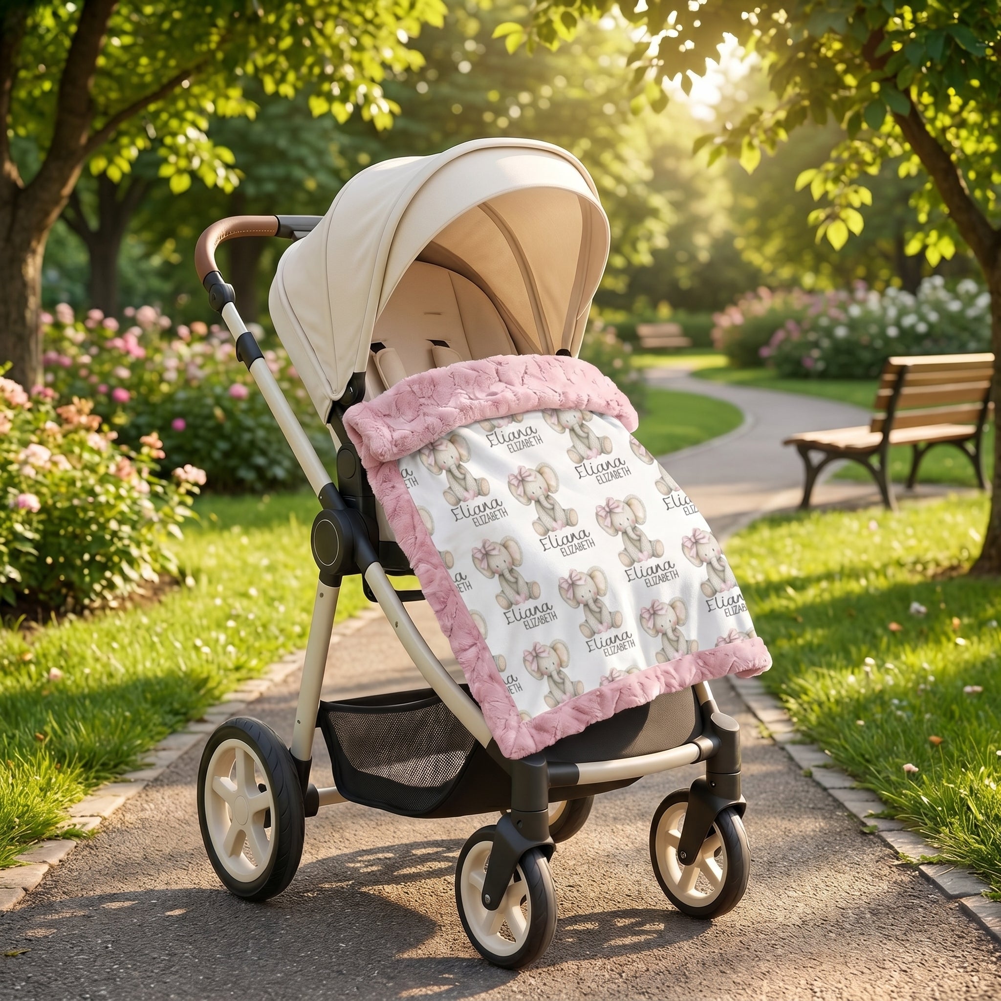Personalized elephant baby blanket with pink minky trim draped over stroller in park