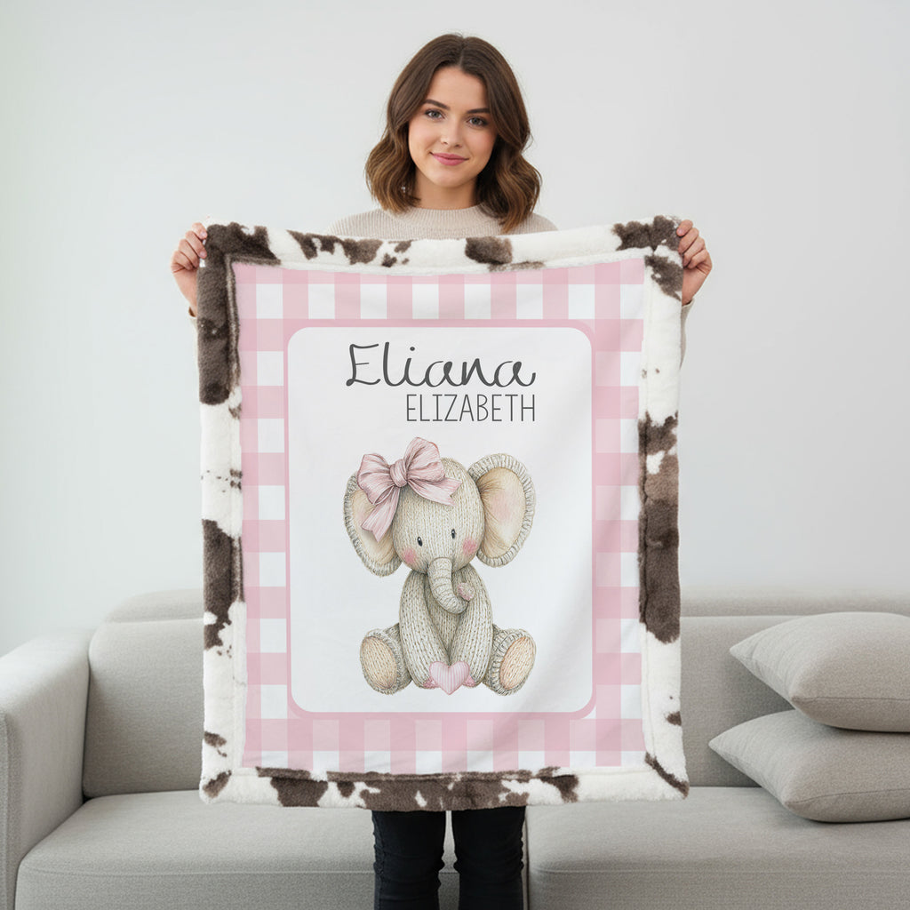 Personalized elephant minky baby blanket with cow print fur backing, held up indoors