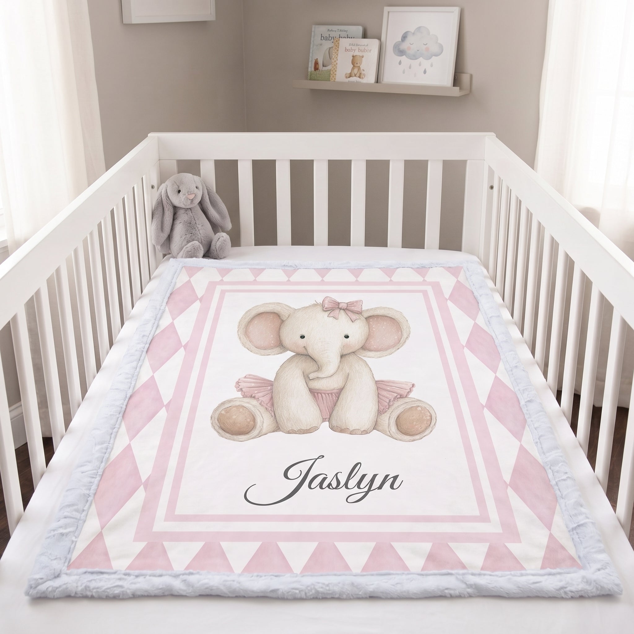 Personalized elephant minky blanket laid flat in crib with plush bunny