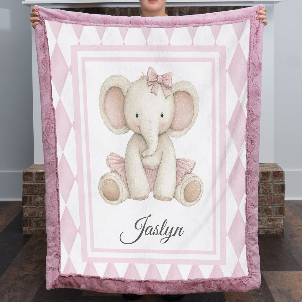 Personalized elephant minky baby blanket with mauve fur trim, held up by fireplace