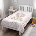 Personalized elephant minky blanket laid flat on toddler bed with toys nearby
