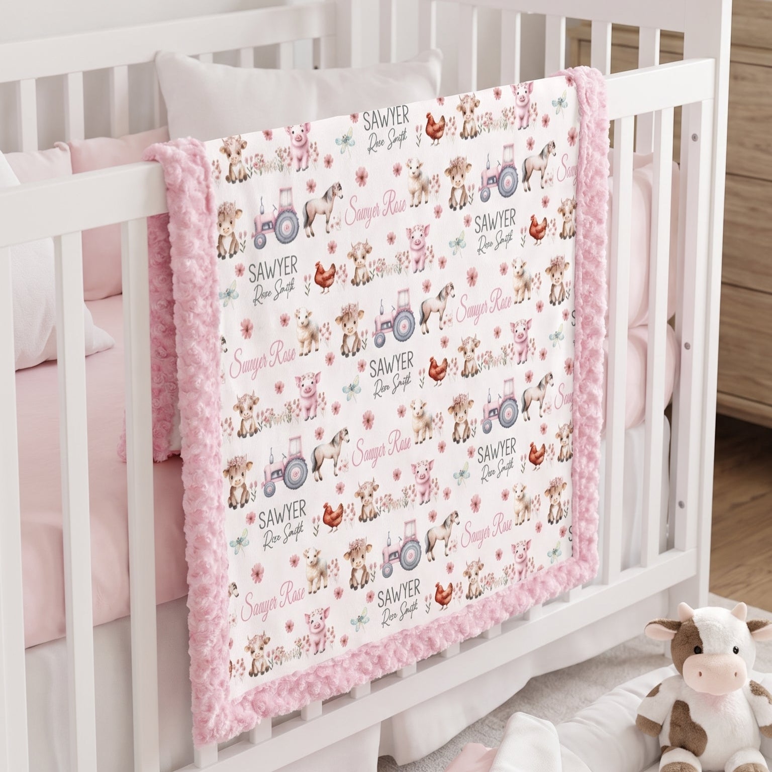 Personalized farm animal minky baby blanket draped over crib rail in nursery