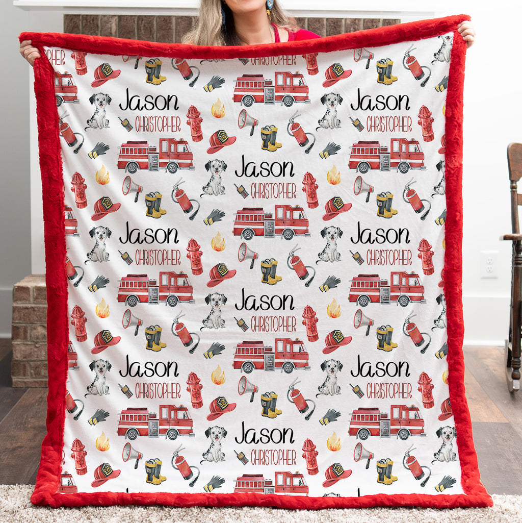 Personalized firefighter baby blanket with red faux fur border, held by woman in front of fireplace