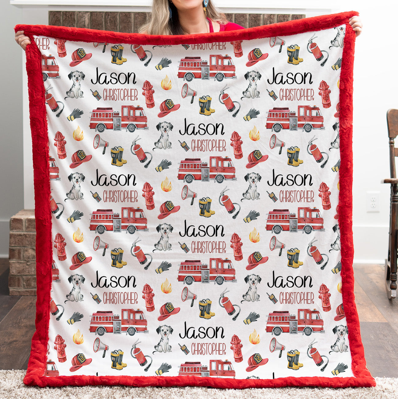 Personalized firefighter baby blanket with red faux fur border, held by woman in front of fireplace