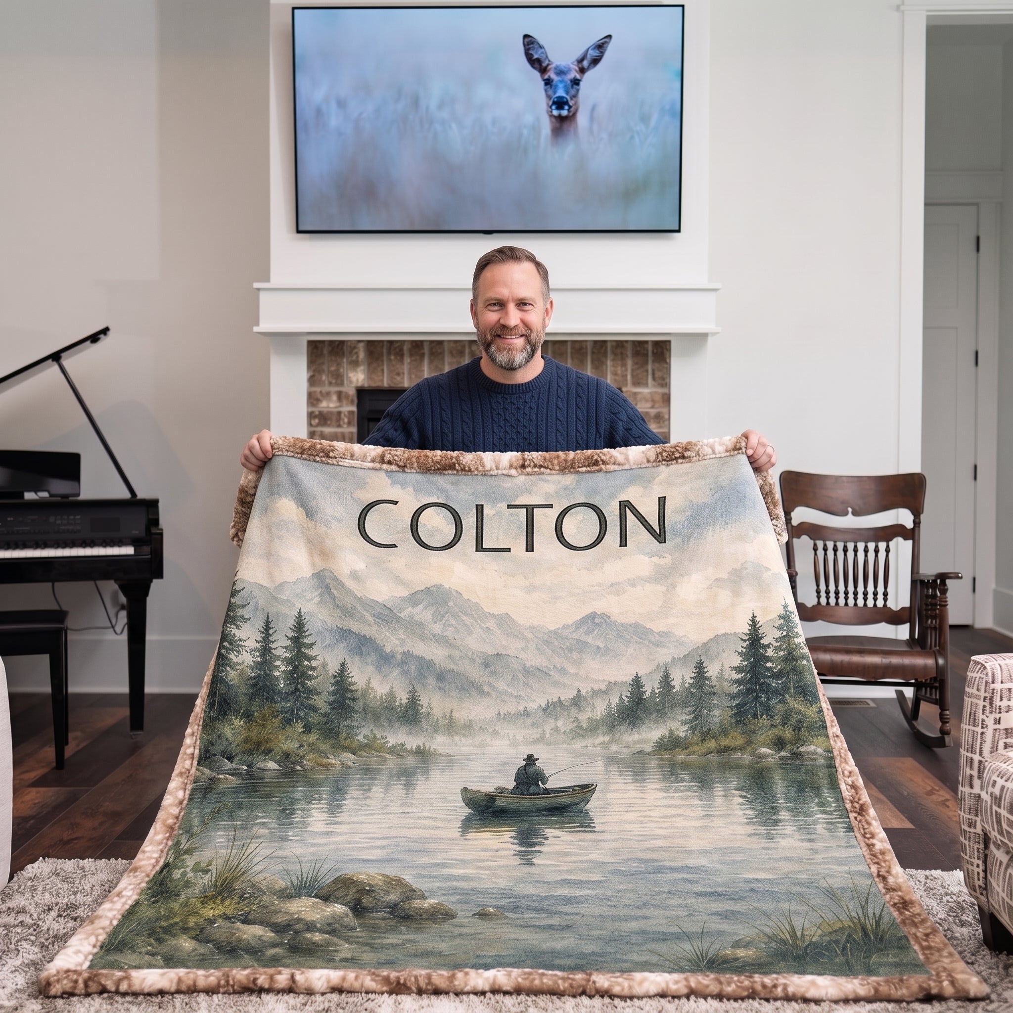 Man holding up personalized fishing lake blanket in cozy living room by the fireplace
