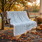 Personalized floral gingham Luxe Cuddle blanket with white trim draped on porch swing in fall