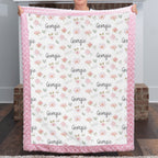 Woman holding personalized floral minky blanket with custom name, pink rosette faux fur trim