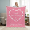 Person holding a pink blanket with text in a living room setting