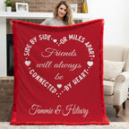 Woman holding personalized friends minky blanket with red self-bound trim by fireplace mantel