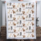Personalized goat and floral minky baby blanket with name held up by a fireplace