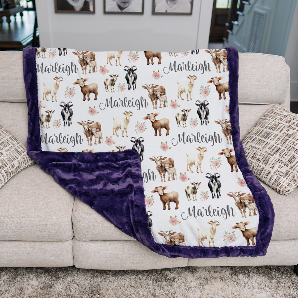 Personalized goat and floral minky blanket draped on couch showing purple minky backing
