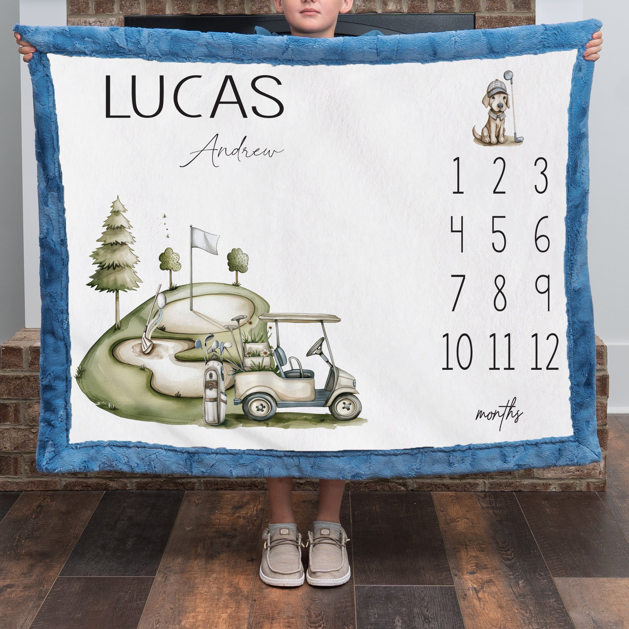 Personalized golf milestone baby blanket with name, held by child in front of brick fireplace