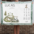 Personalized golf milestone baby blanket with sage faux fur border, held by child against brick wall