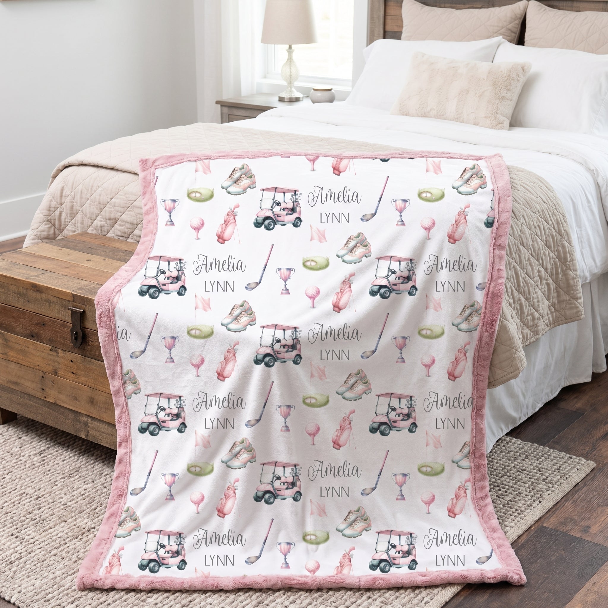 Personalized golf minky blanket with pink trim draped over bed