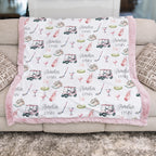 Personalized golf minky blanket with pink trim draped over couch