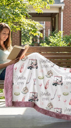 Woman reading on porch bench with personalized golf minky blanket, pink trim