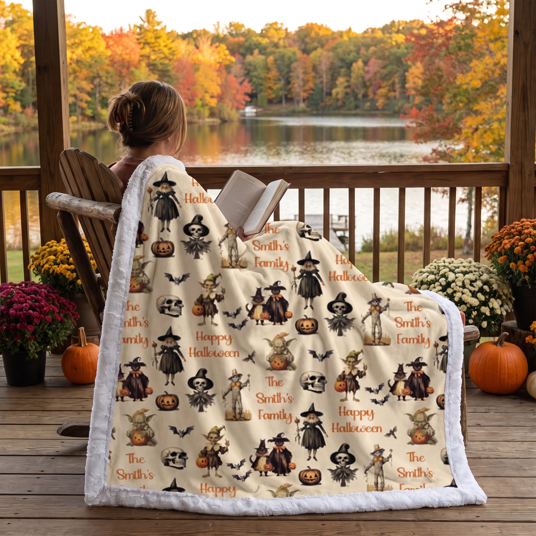 Woman wrapped in personalized Halloween throw blanket reading by lake