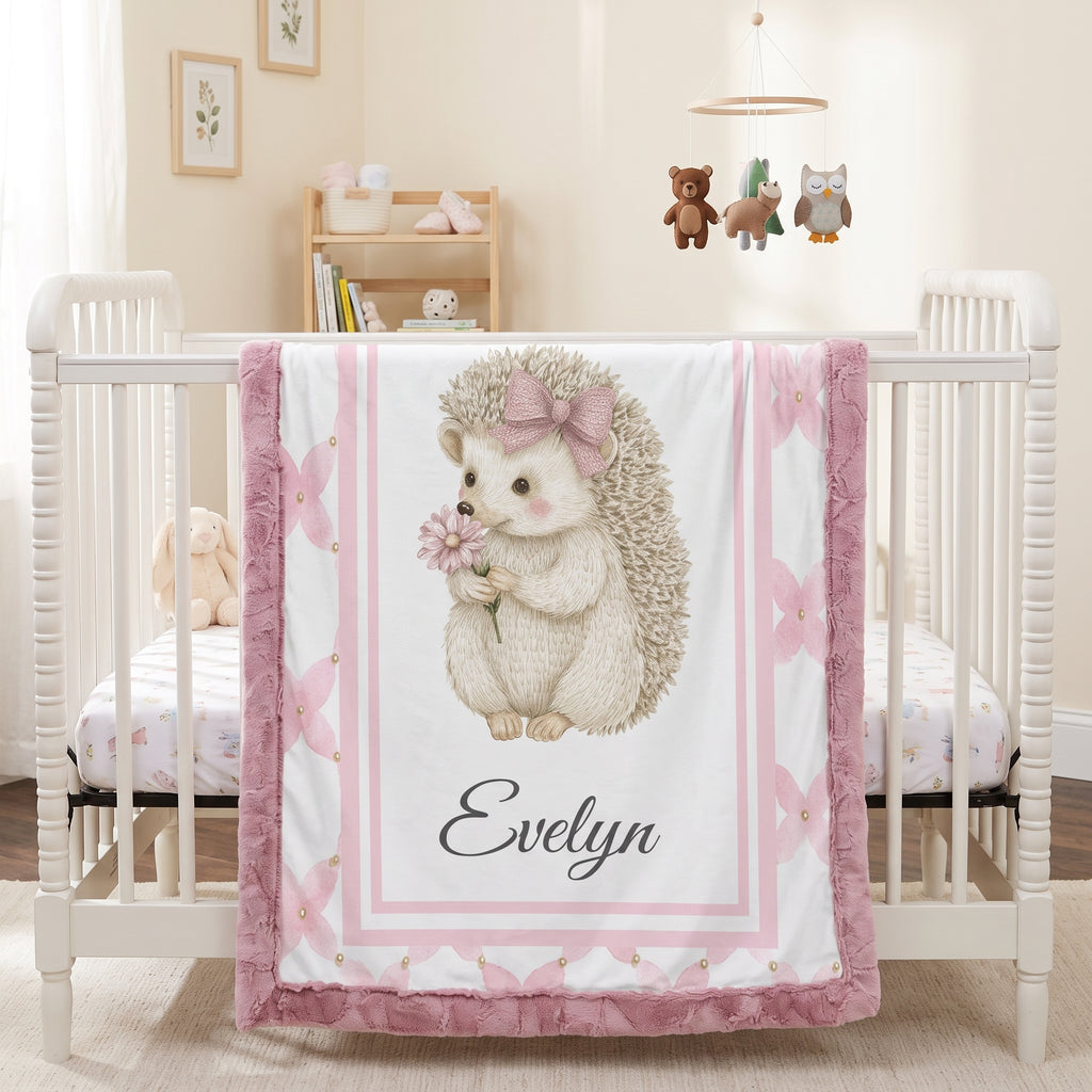 Personalized Luxe Cuddle Minky hedgehog baby blanket draped over white crib in nursery with mobile