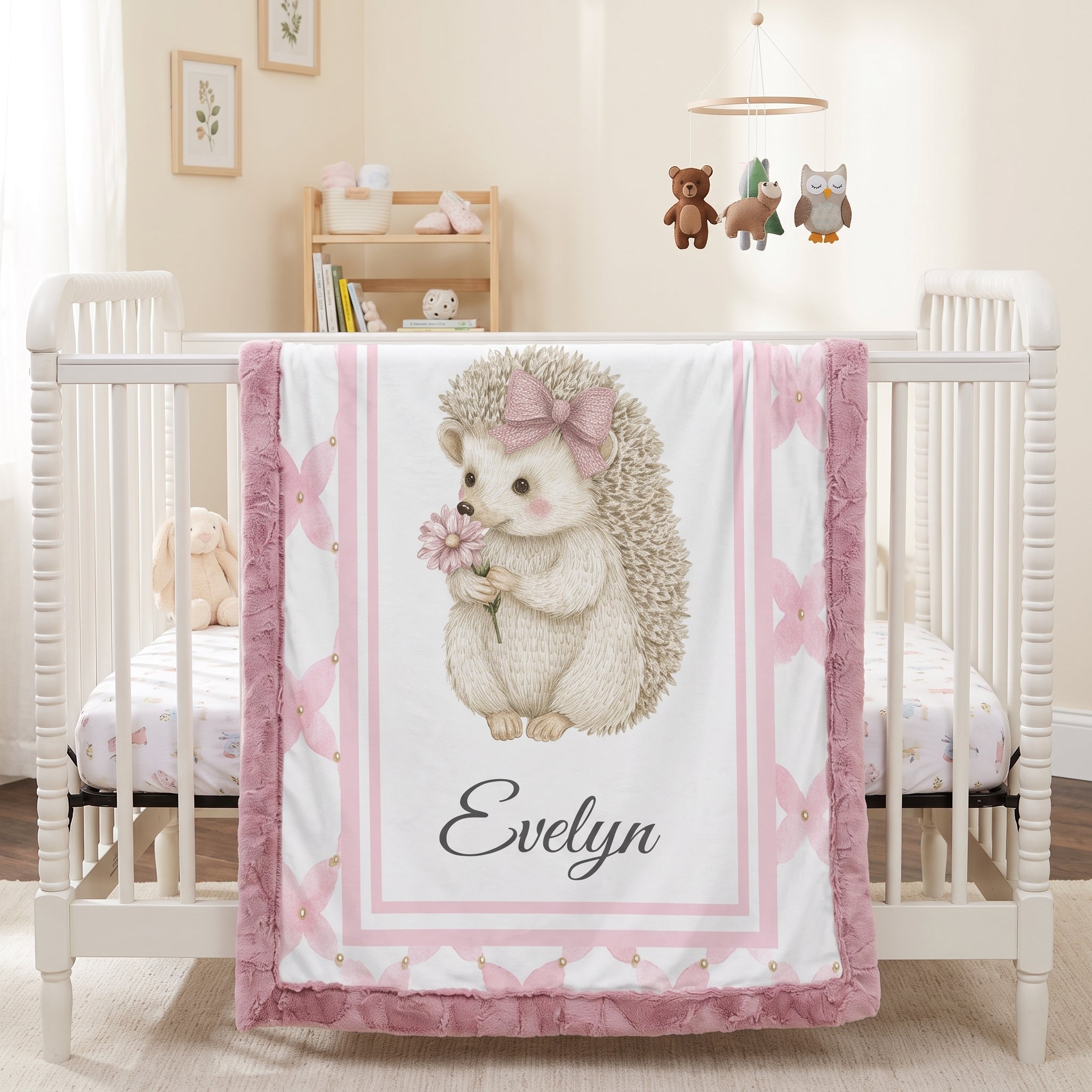 Personalized Luxe Cuddle Minky hedgehog baby blanket draped over white crib in nursery with mobile
