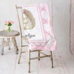 Personalized Luxe Cuddle Minky hedgehog baby blanket draped over rustic chair with pink roses nearby