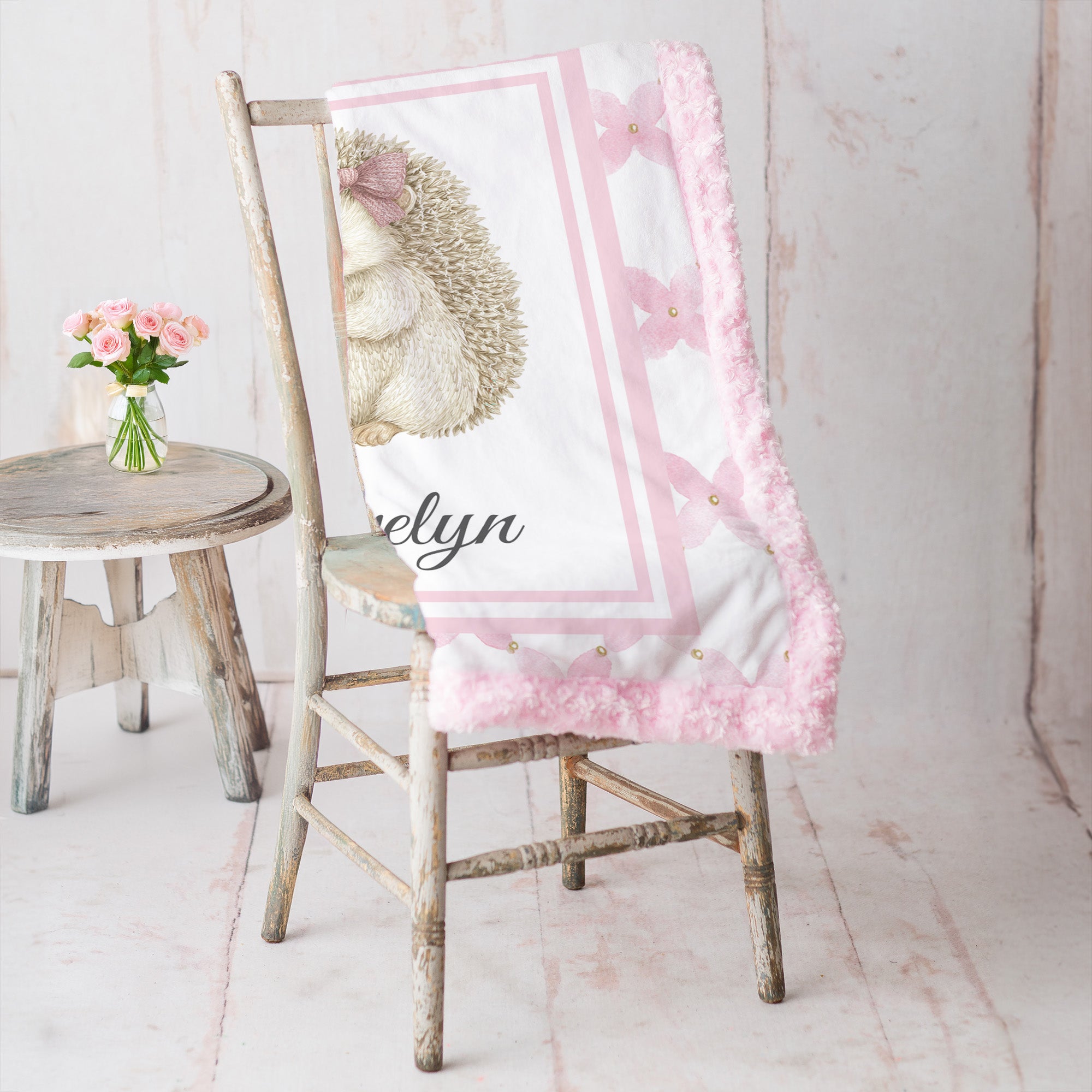 Personalized Luxe Cuddle Minky hedgehog baby blanket draped over rustic chair with pink roses nearby