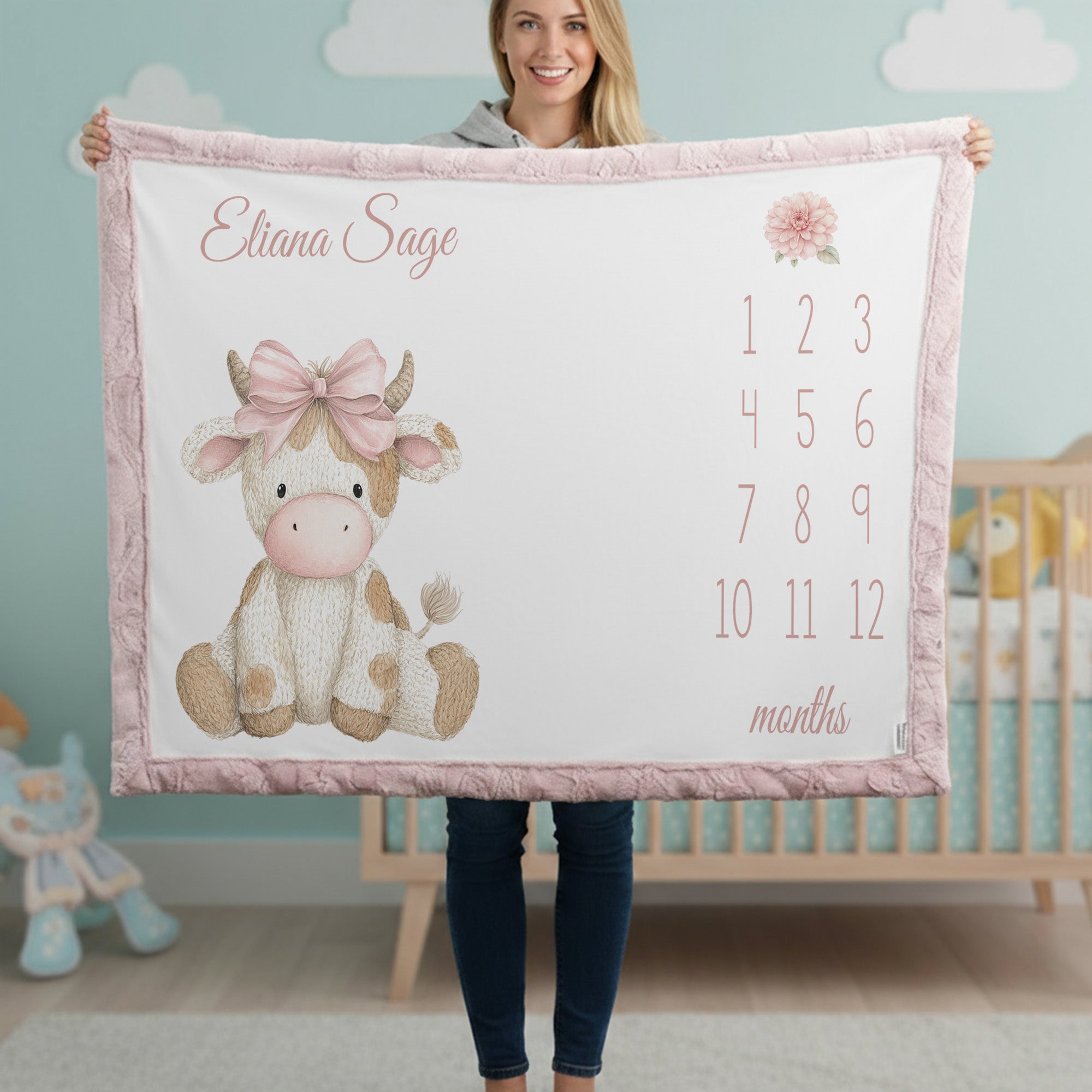 Woman holding personalized highland cow milestone baby blanket with custom name, pink faux fur trim